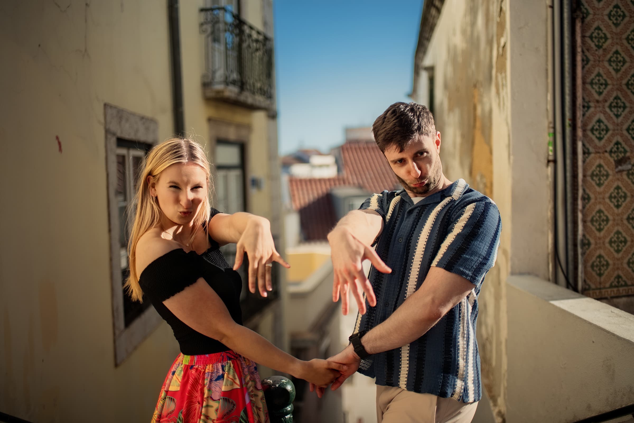 Couple joking and dancing in an Alfama street after their proposal, Lisbon